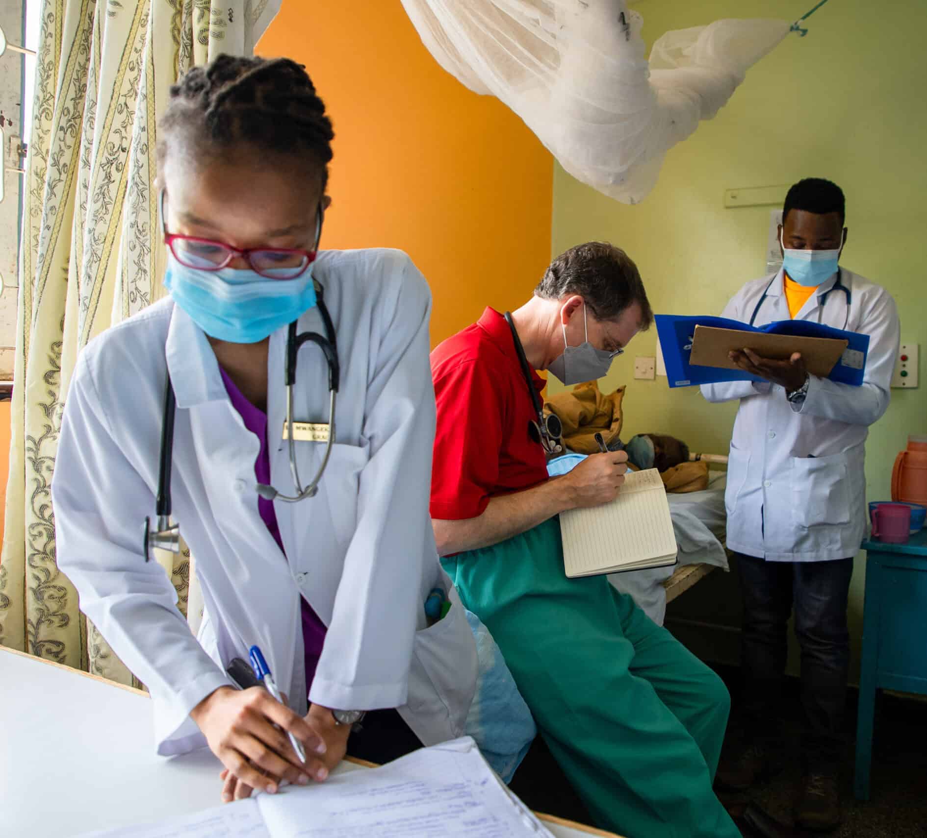 Three doctors work on paperwork