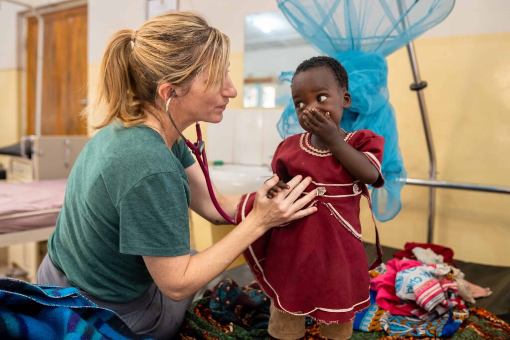 A healthcare worker listens to a toddler's heartbeat with a stethoscope