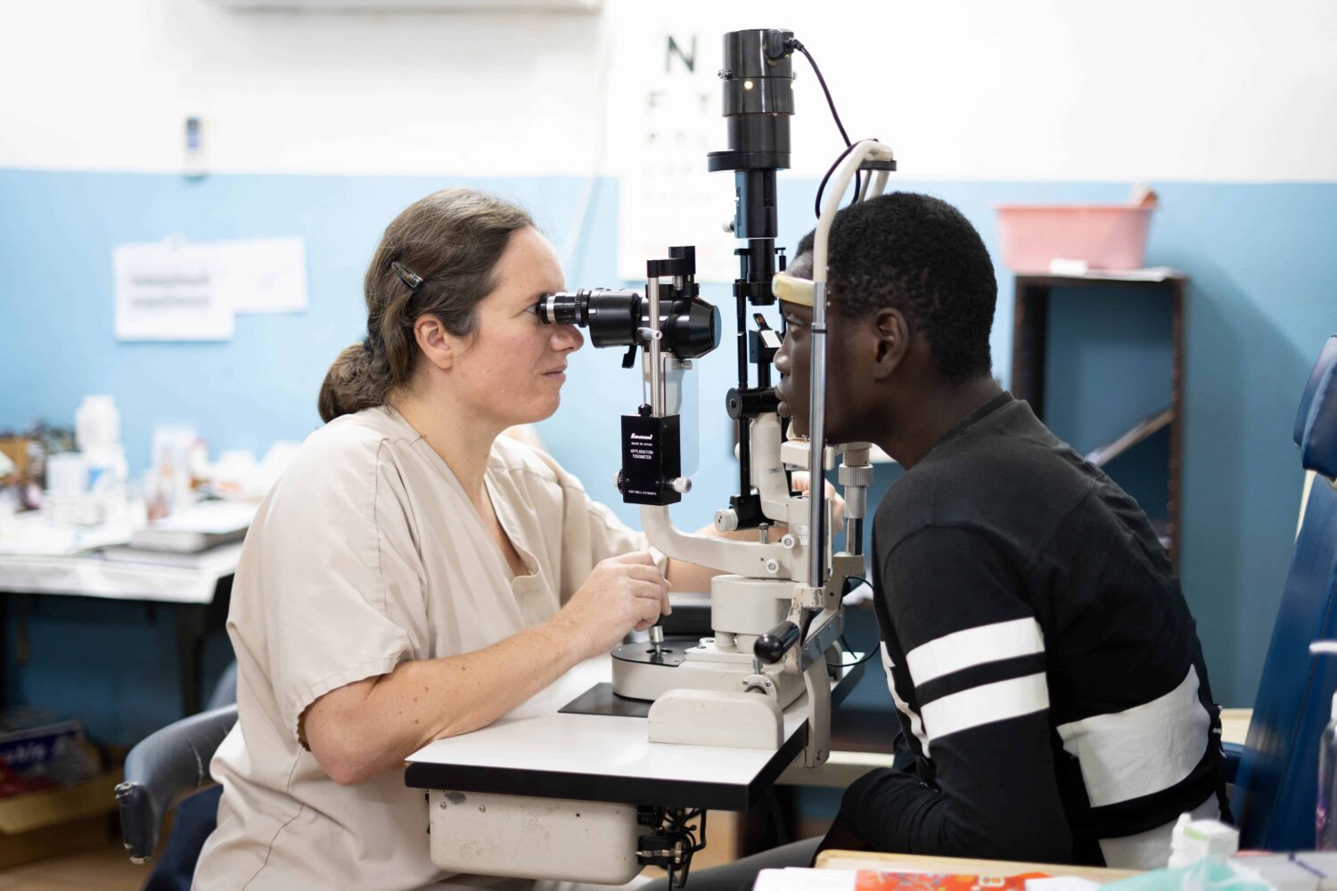 A healthcare worker giving a young man an eye exam