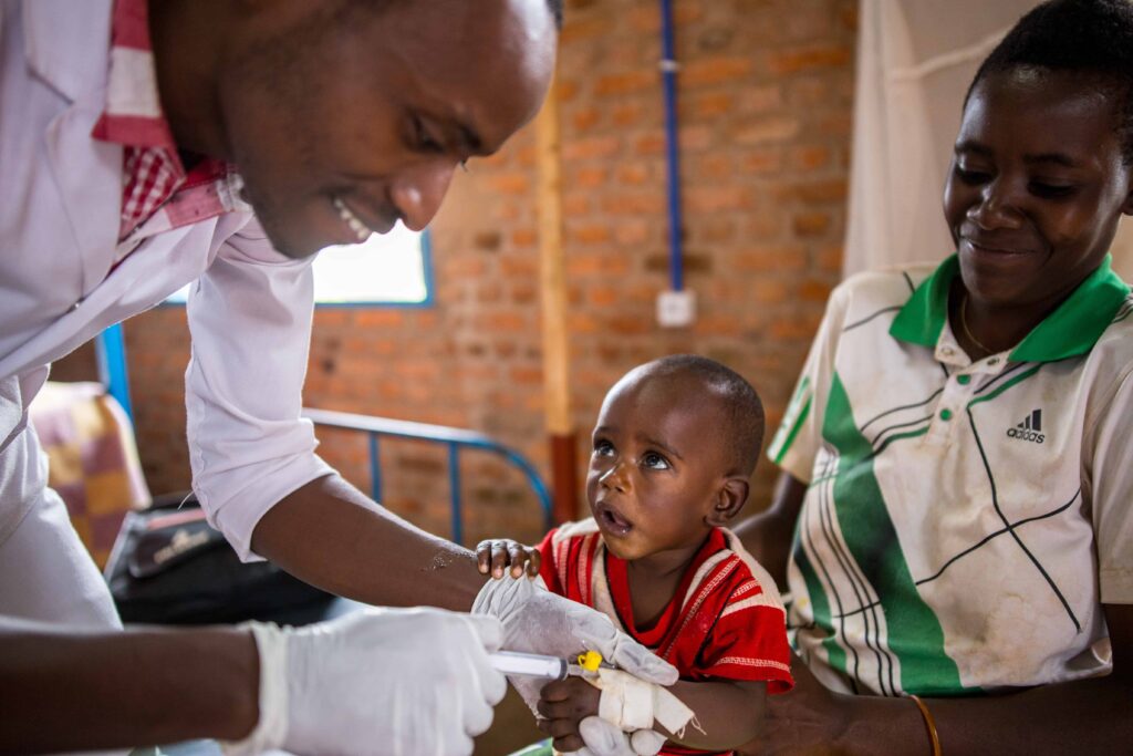 A doctor giving a young boy medicine through an IV