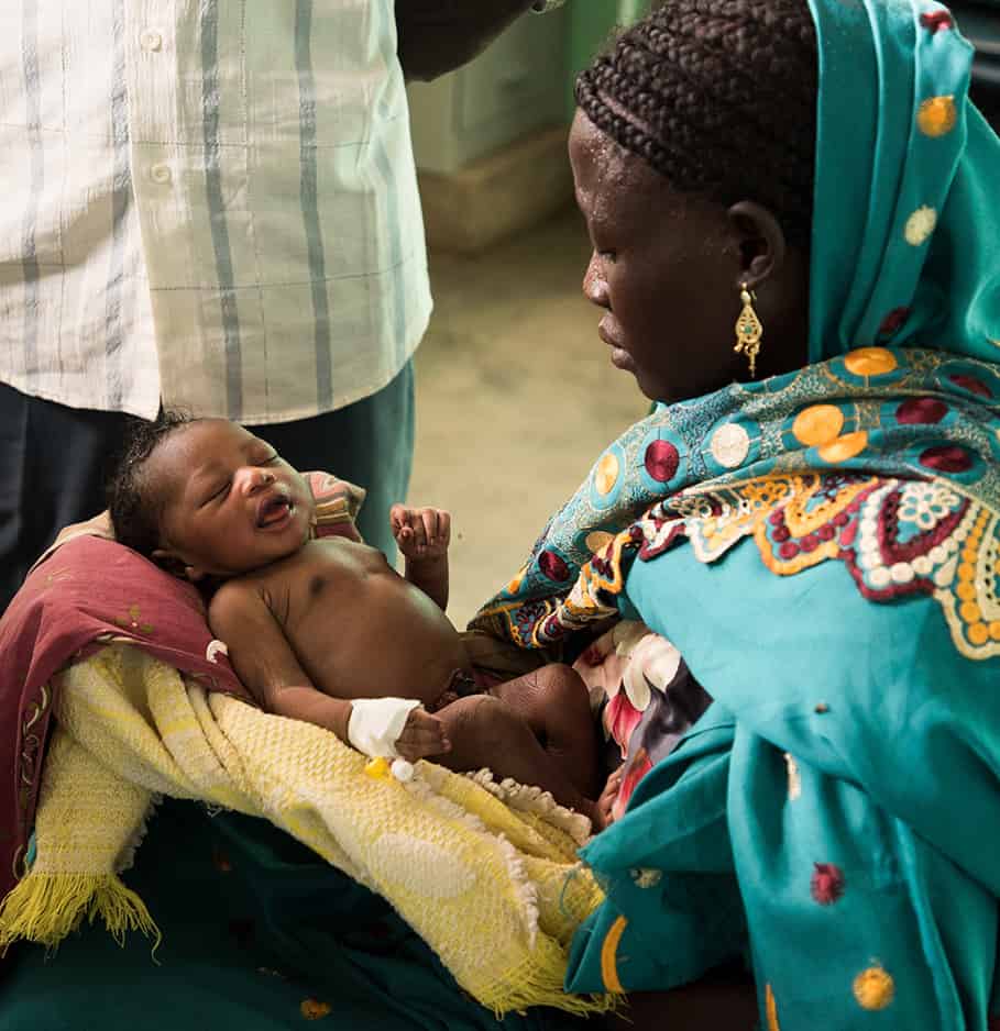 A mother holding her infant child.