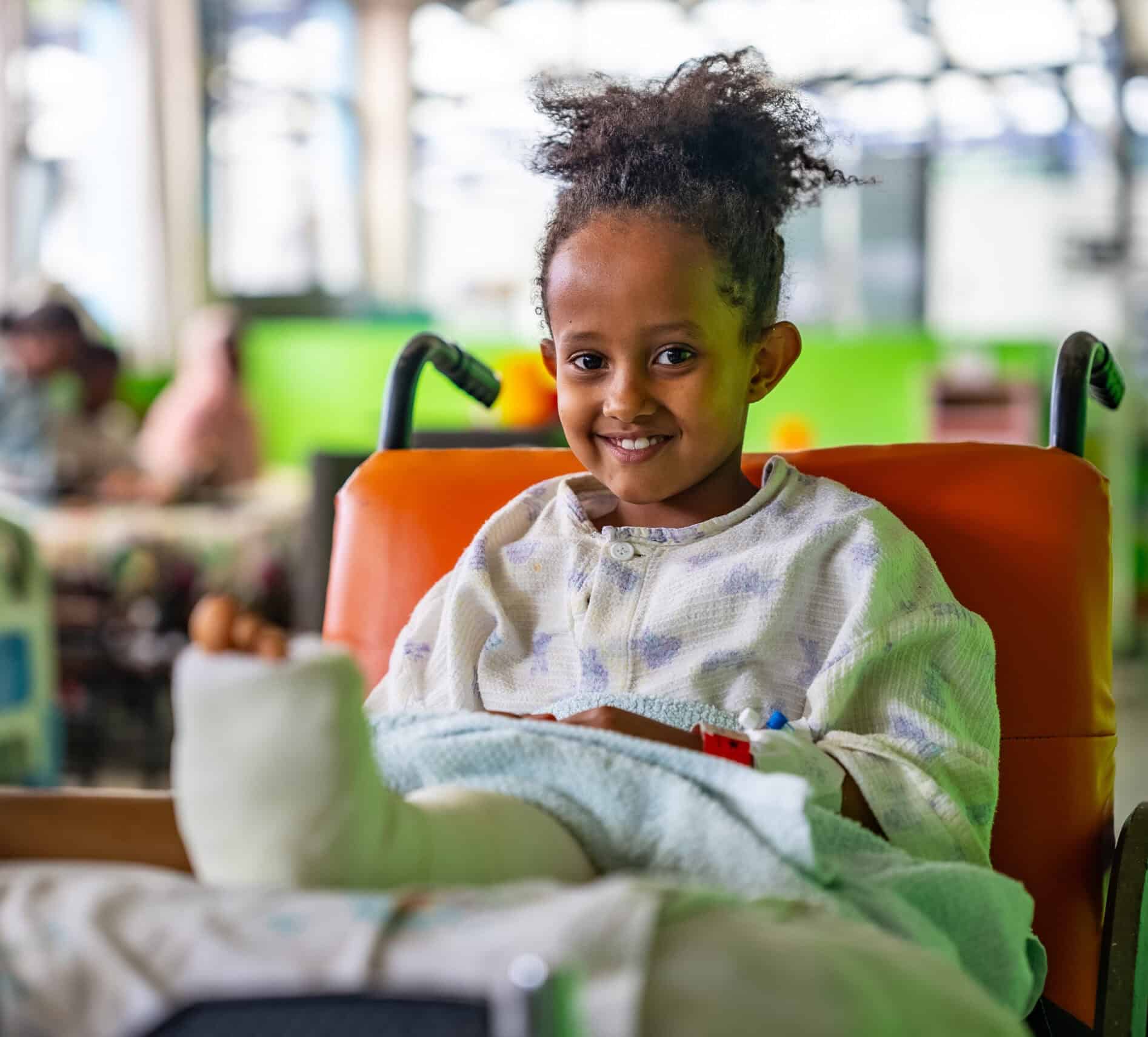 A smiling girl with a cast on her foot